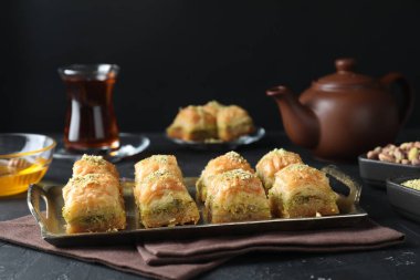Koyu dokulu masada servis edilen doğranmış fındıklı enfes taze baklava. Doğu tatlıları