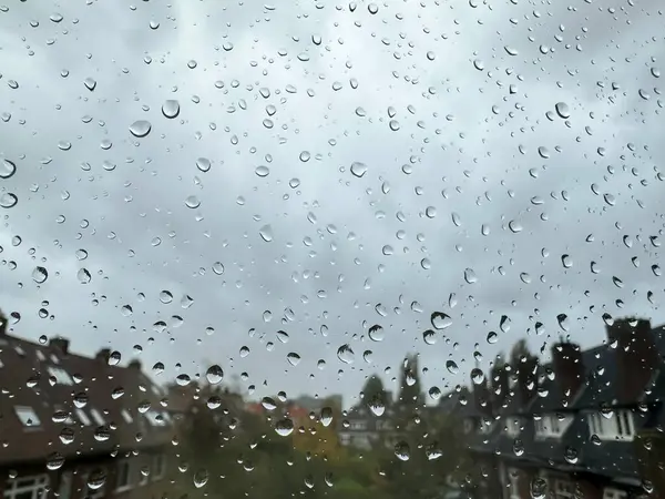Window with water droplets on rainy day, closeup