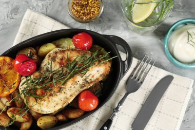 Lezzetli tavuk, sebze, tarhun ve salata soslu içecek gri masada servis edilir.