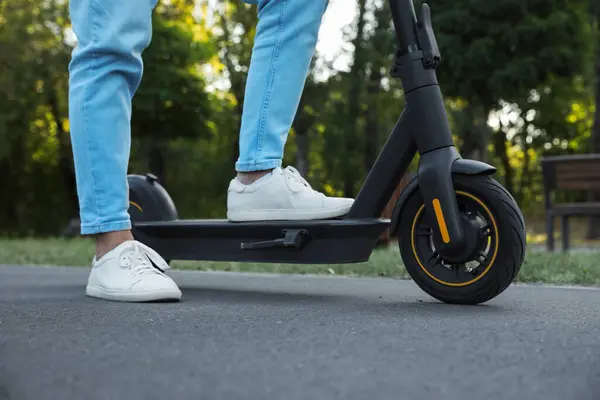 Man with modern electric kick scooter in park, closeup