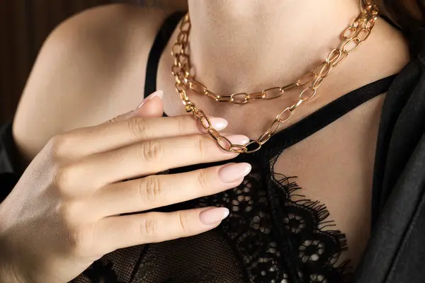 Woman wearing stylish metal chain, closeup. Luxury jewelry