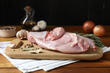 Tahta masada taze çiğ tavşan eti ve baharatlar.