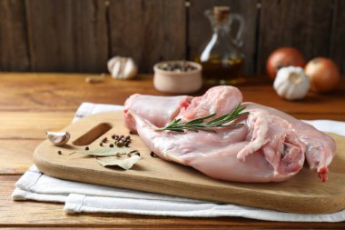 Tahta masada taze çiğ tavşan eti ve baharatlar.