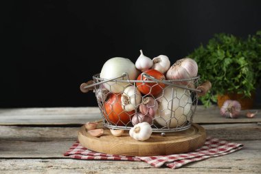 Taze çiğ sarımsak ve soğan ahşap masada, siyah arka planda, metin için yer var.