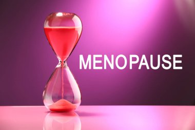 Mor arkaplanda menopoz kelimesi ve kum saati