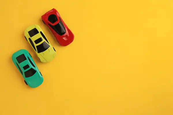 노란색 배경에 자동차 텍스트에 어린이 장난감 — 스톡 사진