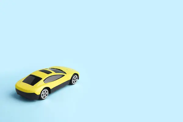 ライトブルーの背景の黄色い車 テキストのためのスペース 子供のおもちゃ — ストック写真