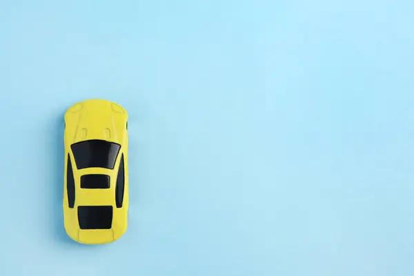 ライトブルーの背景にある1つの黄色い車 テキスト用のスペース付きのトップビュー 子供のおもちゃ — ストック写真