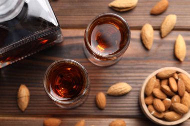 Lezzetli amaretto ile liqueur bardaklar ve ahşap masa üzerinde badem, düz yatar