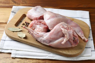 Tahta masada taze çiğ tavşan eti ve baharatlar.