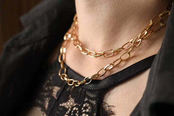 Woman wearing stylish metal chain, closeup. Luxury jewelry