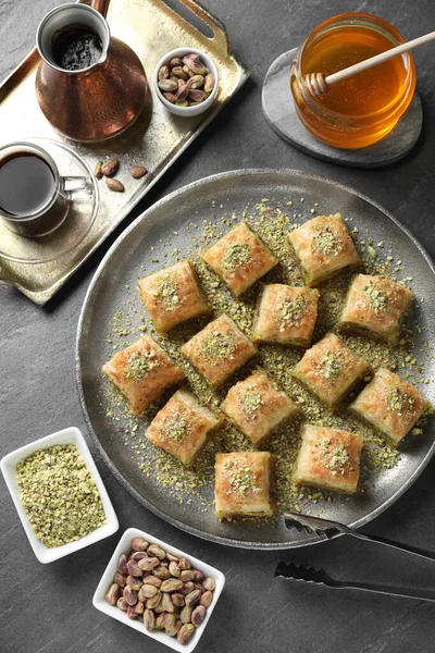 Gri masada servis edilen doğranmış fındıklı enfes taze baklava. Doğu tatlıları