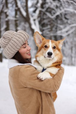 Parkta sevimli Pembroke Galli Corgi köpeği olan bir kadın.