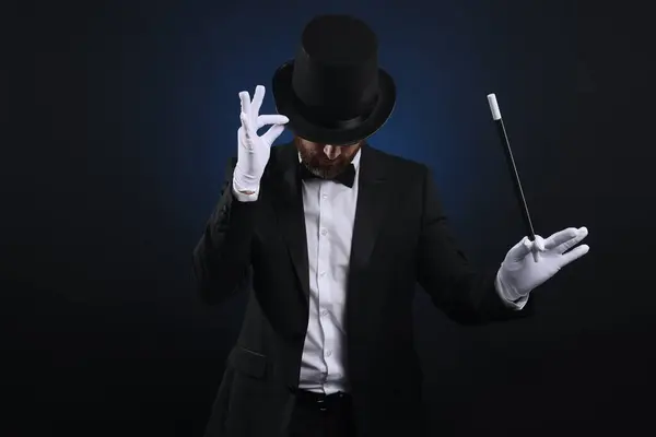 Magician in top hat holding wand on dark blue background