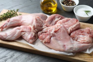 Taze çiğ tavşan bacakları siyah masada, yakın plan.