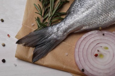 Çiğ dorado balığı, baharatlar ve soğan beyaz ahşap masa, düz uzanmış