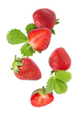 Taze olgun çilekler ve yeşil yapraklar beyaz arka plana dökülüyor.