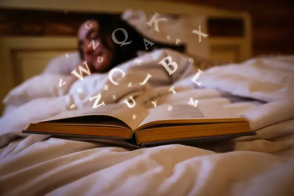 Woman sleeping in bed at home, focus on open book with letters flying over it
