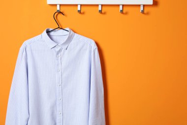 Turuncu duvarda çizgili tişört askısı, mesaj için boşluk