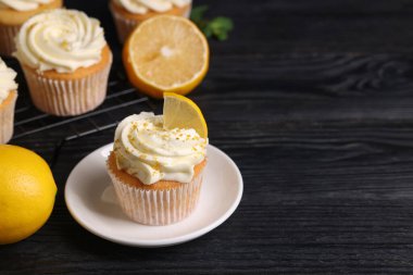 Beyaz kremalı, limonlu ve siyah ahşap masada limonlu lezzetli kekler, yakın plan. Metin için boşluk