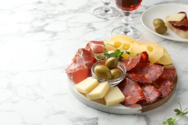 Lezzetli jambon, peynir, sosis ve zeytinli servis masası beyaz mermer masa, yazı için yer
