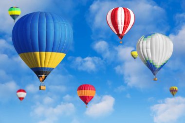 Gökyüzünde bir sürü parlak sıcak hava balonu uçuşuyor.