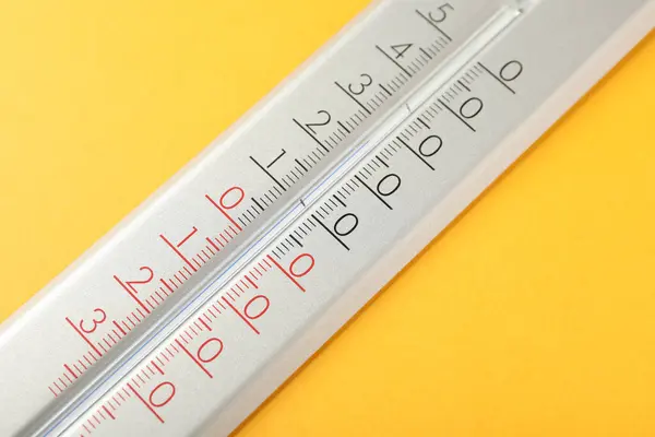 Modern weather thermometer on yellow background, closeup