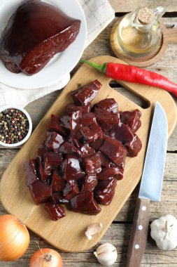 Çiğ sığır ciğeri ve ürünleri ahşap masaya koyun.