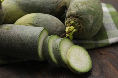 Yeşil Daikon turpları ahşap masada, yakın plan.