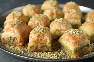 Gri masada doğranmış fındıklı enfes taze baklava, yakın plan. Doğu tatlıları