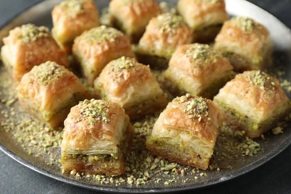 Delicious fresh baklava with chopped nuts on grey table, closeup. Eastern sweets