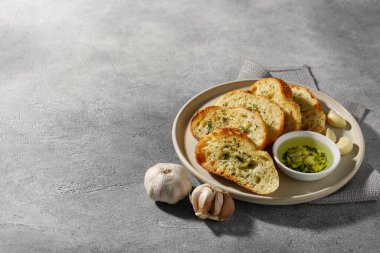 Gri desenli masada servis edilen sarımsak ve dereotlu baget, yazı için yer.