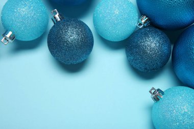 Açık mavi arka planda Noel topları, üst manzara. Metin için boşluk