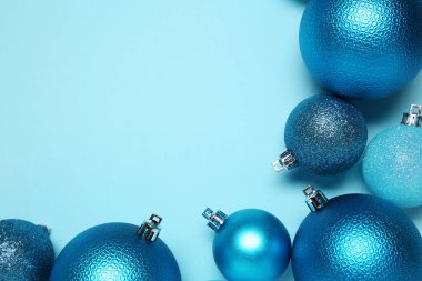 Açık mavi arka planda Noel topları, üst manzara. Metin için boşluk