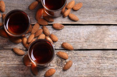 Lezzetli amaretto likörü ve ahşap masada badem. Metin için boşluk