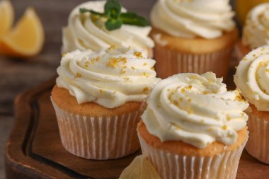 Tahta tahtada beyaz kremalı ve limonlu lezzetli kekler, yakın plan.