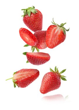 Beyaz arka plana düşen taze olgun çilekler.