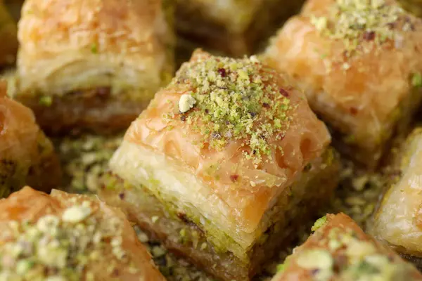 Delicious fresh baklava with chopped nuts on table, closeup. Eastern sweets