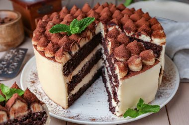 Nefis tiramisu keki, üzerinde nane yaprakları, ahşap masa, yakın plan.