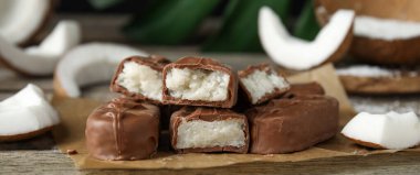 Tahta masada hindistan cevizli çikolatalı çikolatalar, yakın plan. Pankart tasarımı