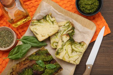 Tahta masada servis edilen fesleğenli taze pişmiş pesto ekmeği.