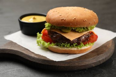 Köfteli lezzetli hamburger ve siyah masada sos, yakın plan.