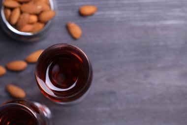 Lezzetli amaretto ile liqueur bardaklar ve ahşap masa üzerinde badem, düz yatak. Metin için boşluk
