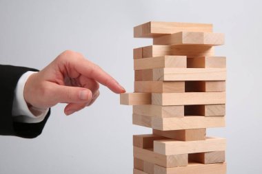 Açık gri arka planda Jenga oynayan kadın, yakın plan