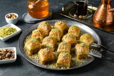 Gri masada servis edilen doğranmış fındıklı enfes taze baklava. Doğu tatlıları