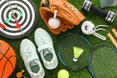 Farklı spor aletleri ve yeşil çimlerde spor ayakkabıları, düz yatış
