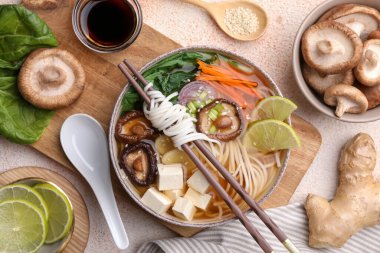 Vejetaryen ramen, yemek çubukları ve hafif desenli masa malzemesi.