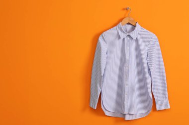 Turuncu duvarda çizgili tişört askısı, mesaj için boşluk