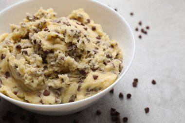 Çikolata parçalı kurabiye hamuru açık gri masada, yakın plan.