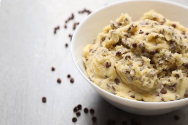 Açık gri masada kasede çikolatalı kurabiye hamuru, yakın plan. Metin için boşluk